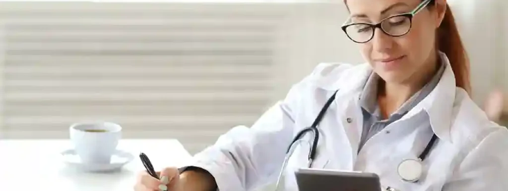 médica-analisando-suas-financas-utilizando-um-tablet-com-papeis-na-mesa médica-analisando-suas-financas-utilizando-um-tablet-com-papeis-na-mesa