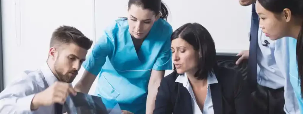 médicos-trabalhando-em-uma-mesa-e-analisando-documentos médicos-trabalhando-em-uma-mesa-e-analisando-documentos